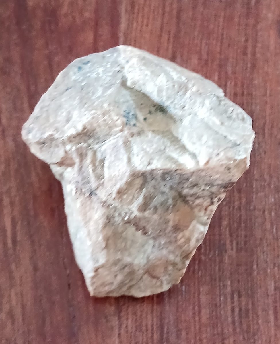 Piedra blanca traída de El Chaltén, apoyada sobre una superficie de madera